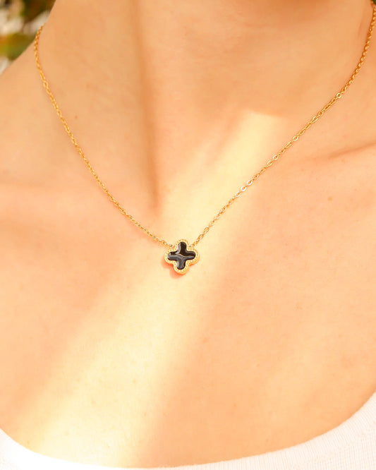 Close-up of four-leaf black clover charm on gold waterproof chain