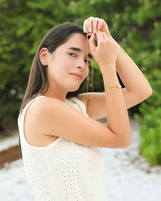 Woman wearing layered necklace facing side view by the water