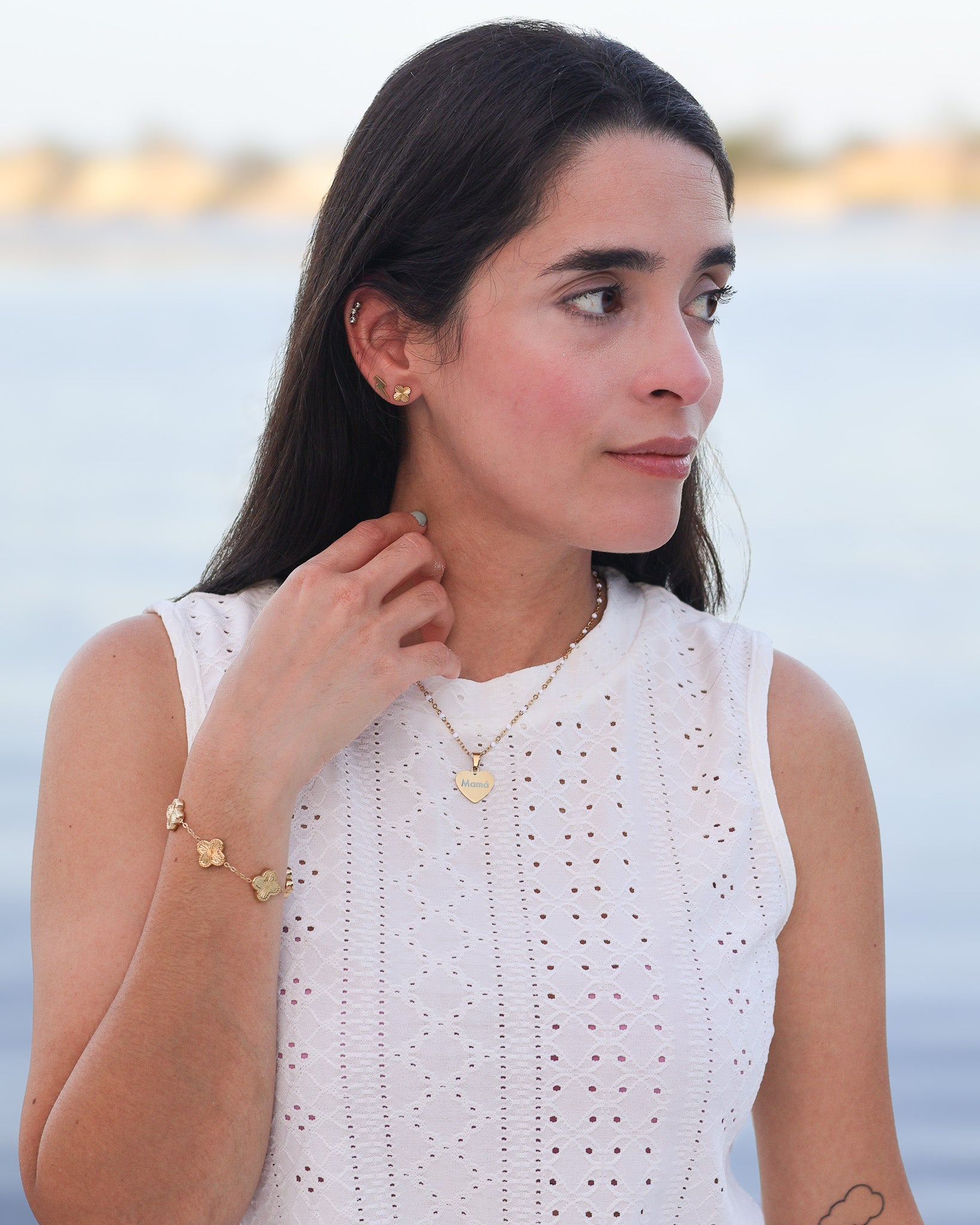Close-up of custom gold heart necklace shimmering under natural light with engraved word visible