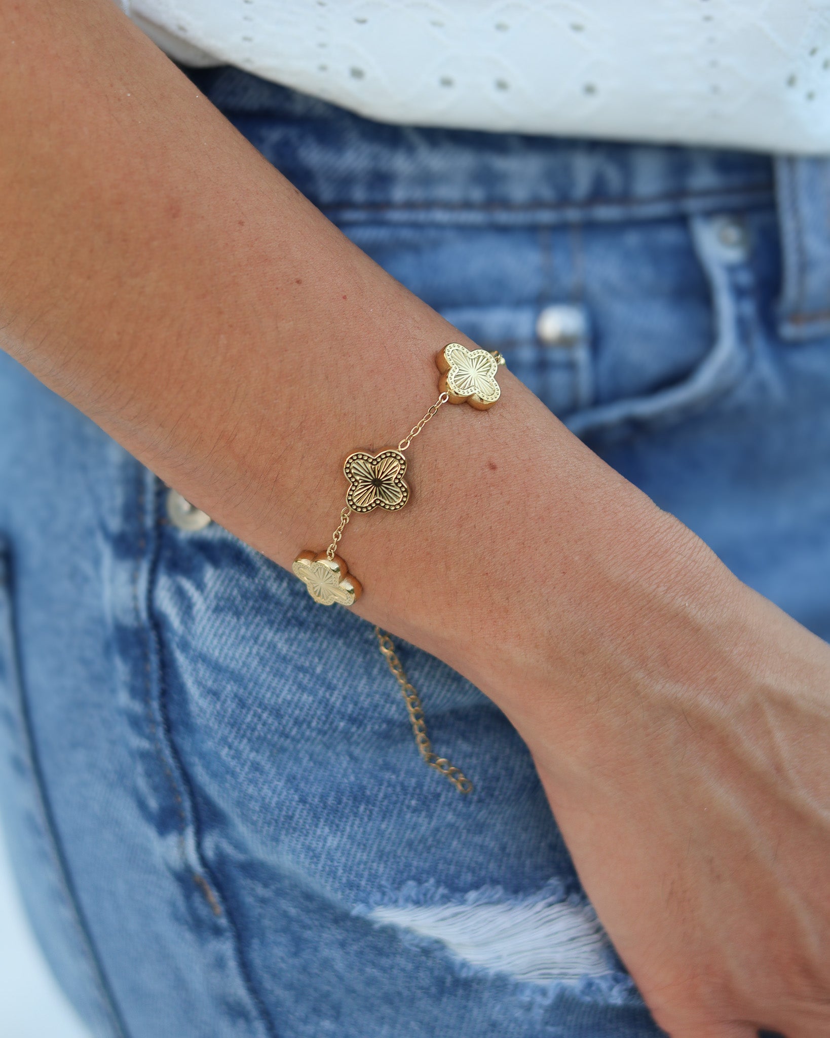 Close-up of textured gold clover charms resting in hand