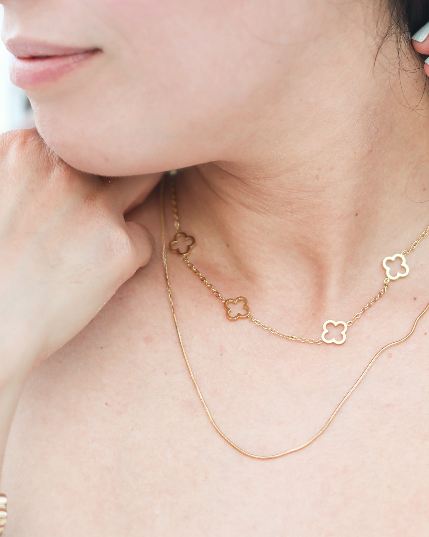 Close-up of gold necklace held in hand outdoors