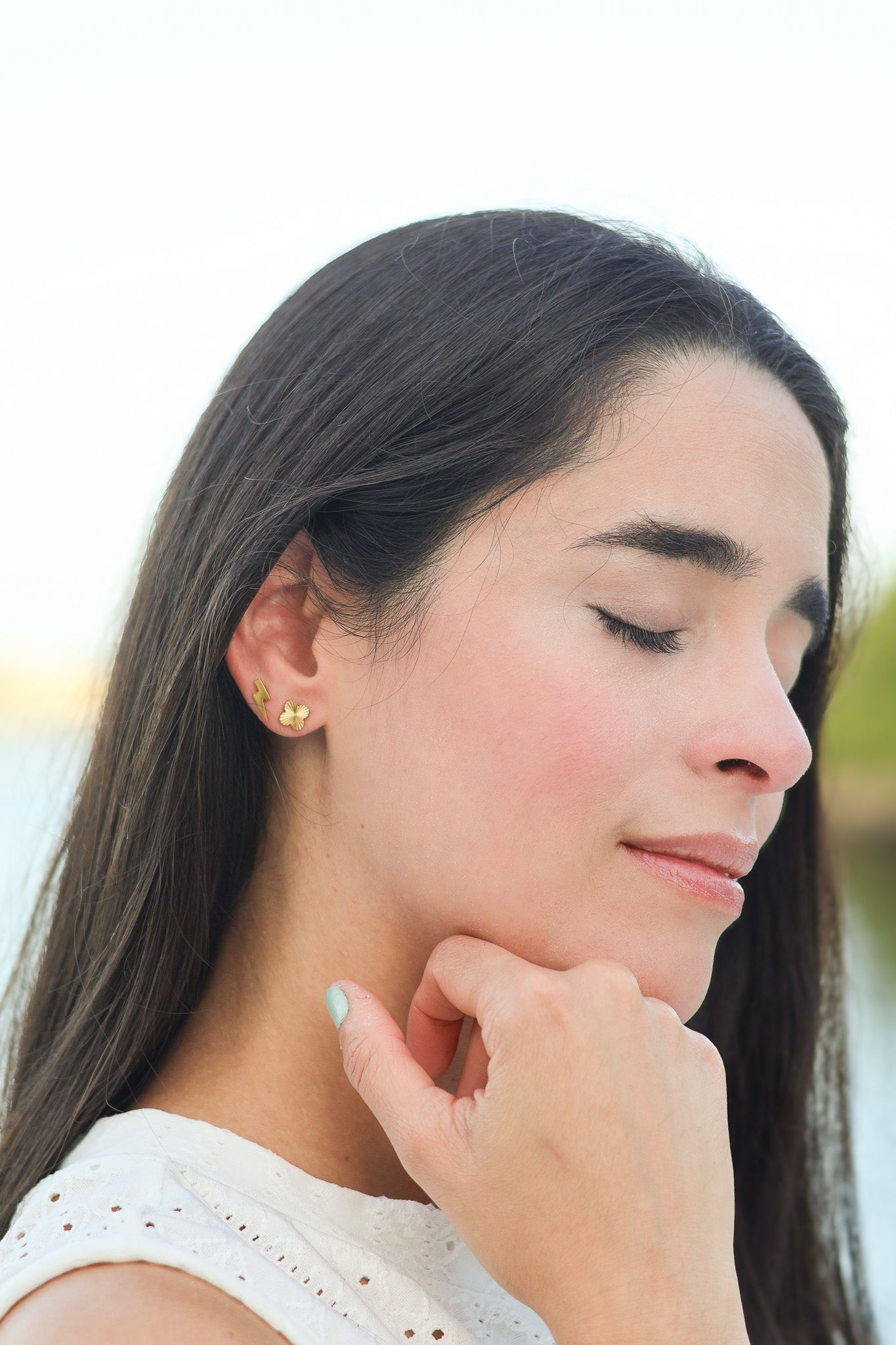 Detailed view of clover earring posts showing 18K gold PVD coating over stainless steel