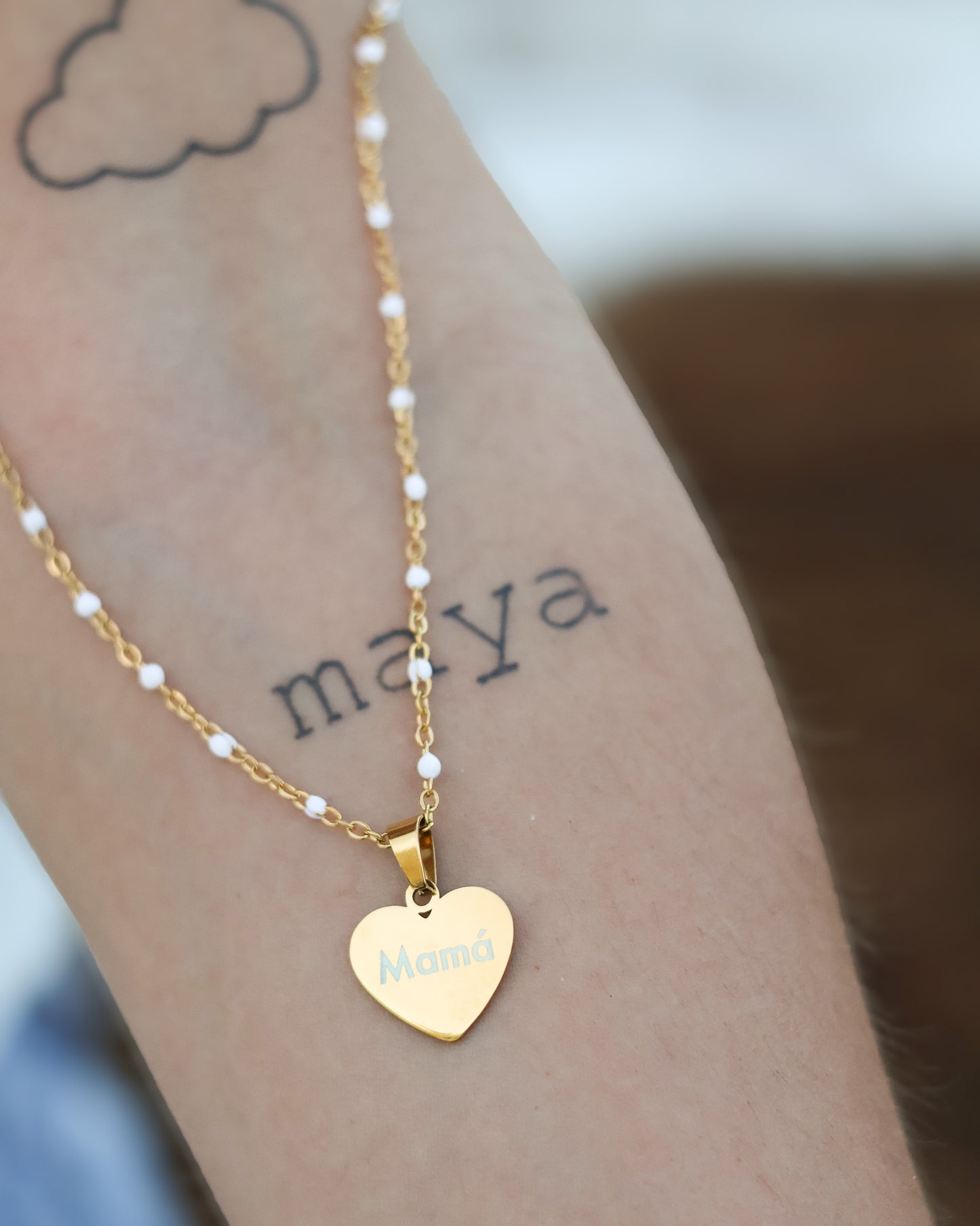 Gold heart charm with engraved text styled as a beach-inspired everyday jewelry piece