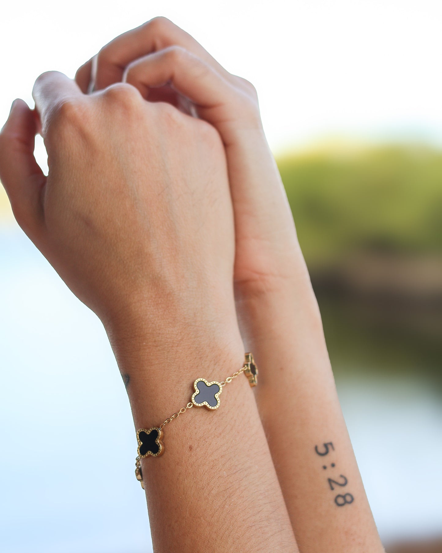 Close-up of waterproof black enamel clover bracelet with extension chain