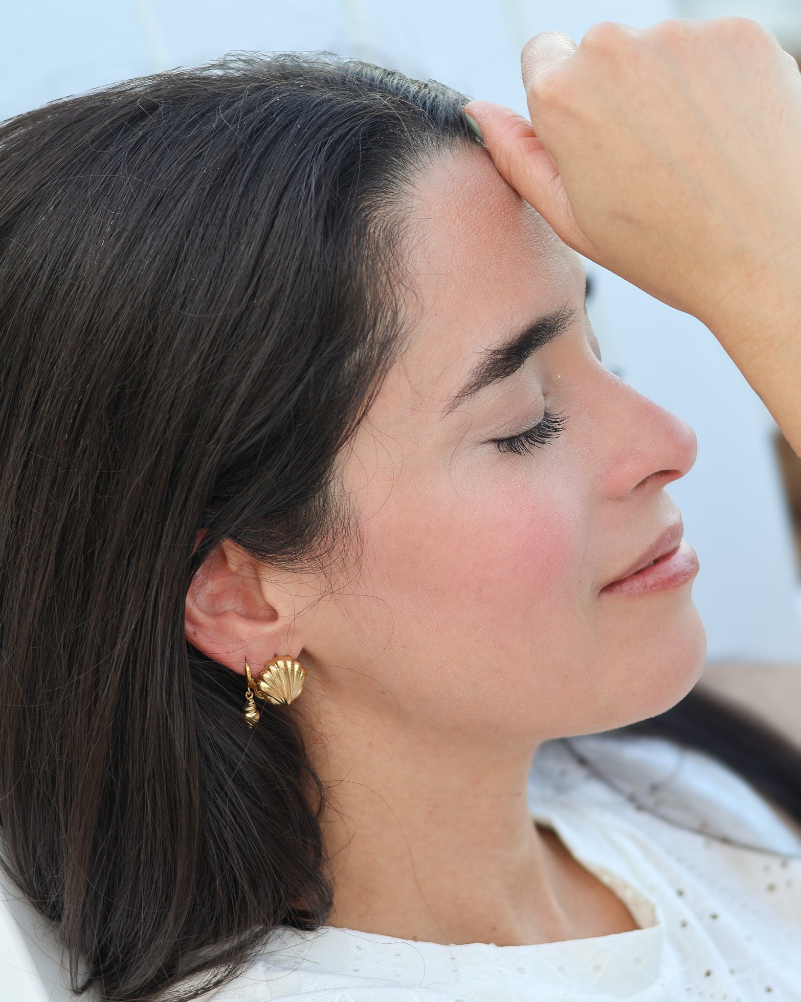 Gold seashell hoop earrings worn with relaxed coastal style